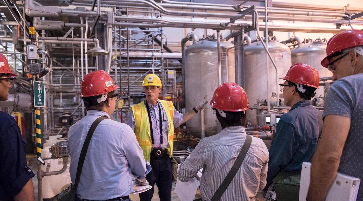 Engineers reviewing equipment inside an operating process facility